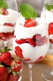 Photo of Delicious strawberries with whipped cream in glass, closeup