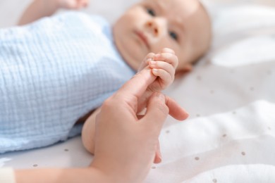 Mother with her cute little baby in crib, selective focus