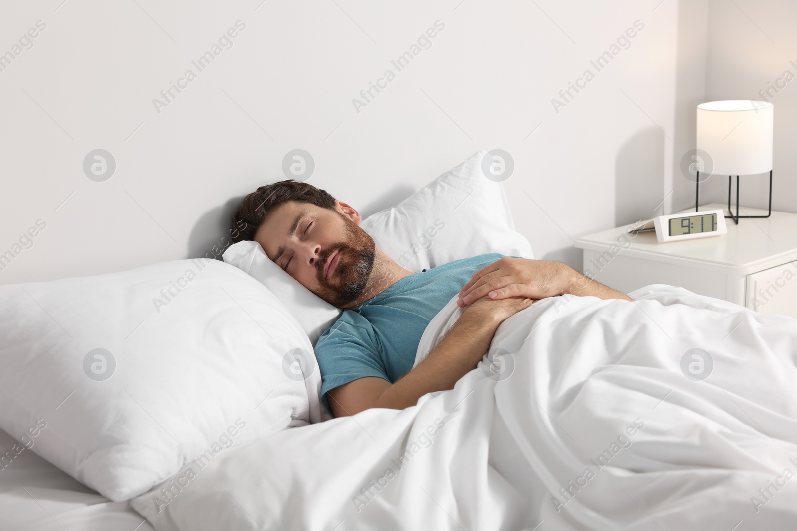 Photo of Man sleeping on comfortable pillows in bed at home