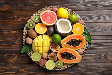 Photo of Fresh ripe papaya and other fruits on wooden table, top view