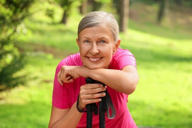 Photo of Senior woman with Nordic walking poles outdoors