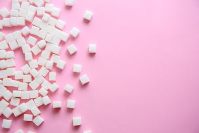 Refined sugar cubes on color background, top view