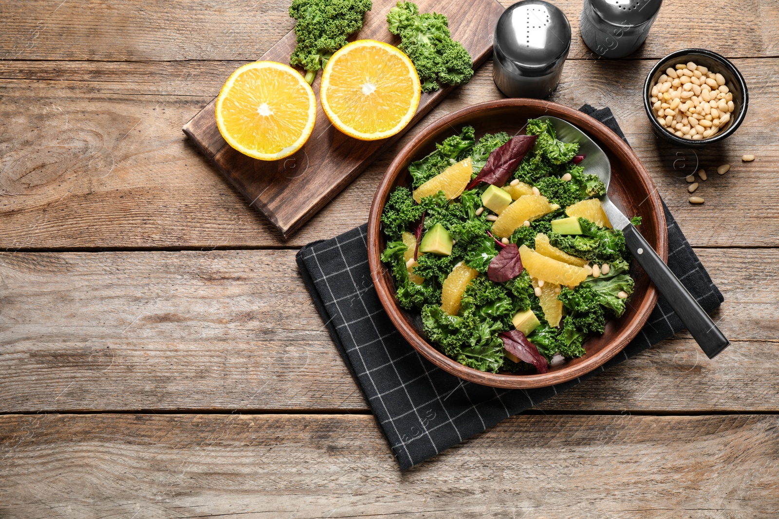 Photo of Tasty fresh kale salad on wooden table, flat lay