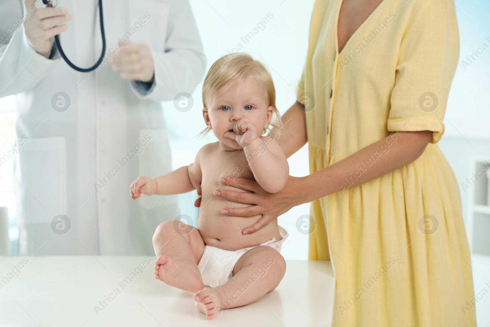 Photo of Mother with her baby visiting pediatrician in hospital. Health growth