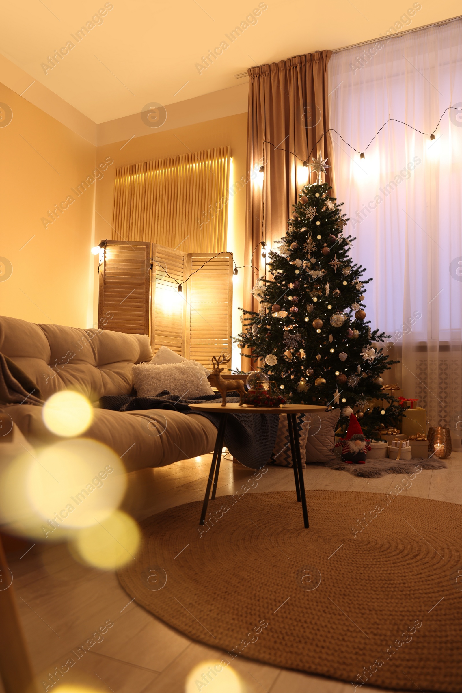 Photo of Beautiful room with tree decorated for Christmas. Bokeh effect