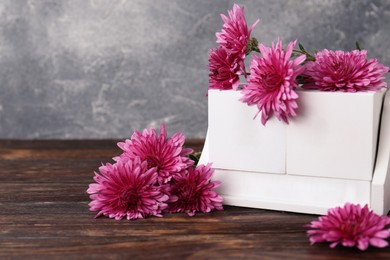 Photo of Thanksgiving day, holiday celebrated every fourth Thursday in November. Block calendar and beautiful chrysanthemums on wooden table. Space for text