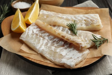 Photo of Fresh raw cod fillets, spices and lemon on table, closeup