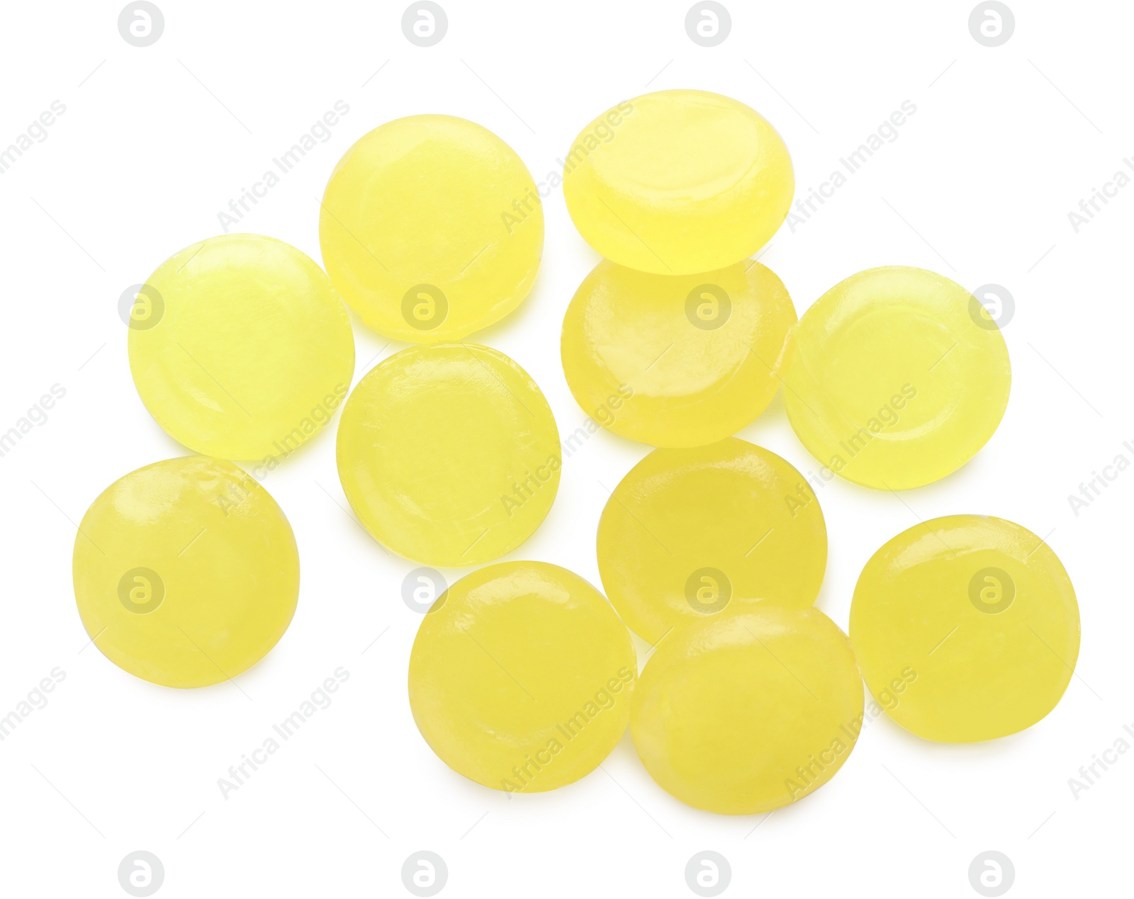 Photo of Many yellow cough drops on white background, top view