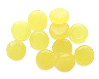 Many yellow cough drops on white background, top view