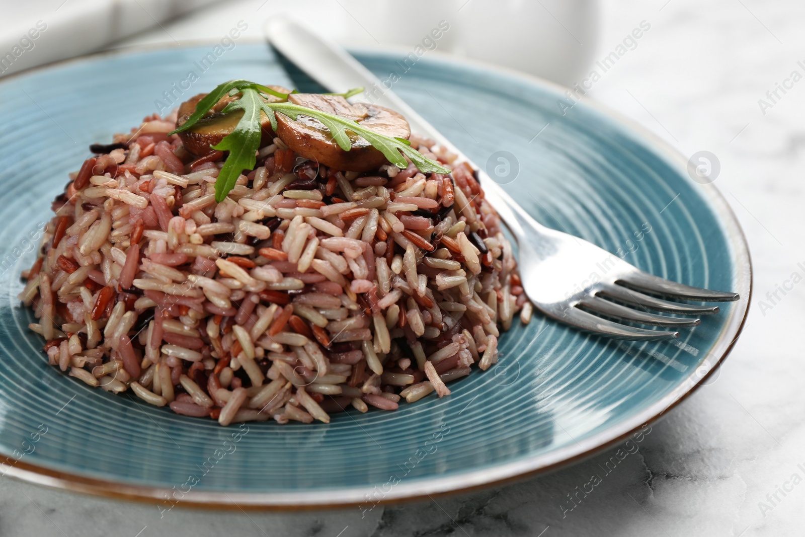 Photo of Tasty brown rice on marble table, closeup