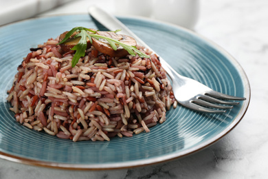 Photo of Tasty brown rice on marble table, closeup