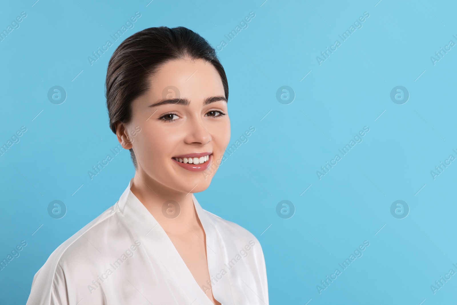 Photo of Portrait of attractive young woman with smooth skin on turquoise background. Space for text