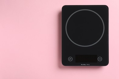 Photo of Modern digital kitchen scale on pink background, top view. Space for text