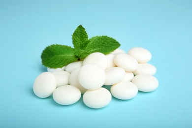 Photo of Tasty mint candies and leaves on color background