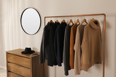 Modern dressing room interior with stylish clothes and mirror