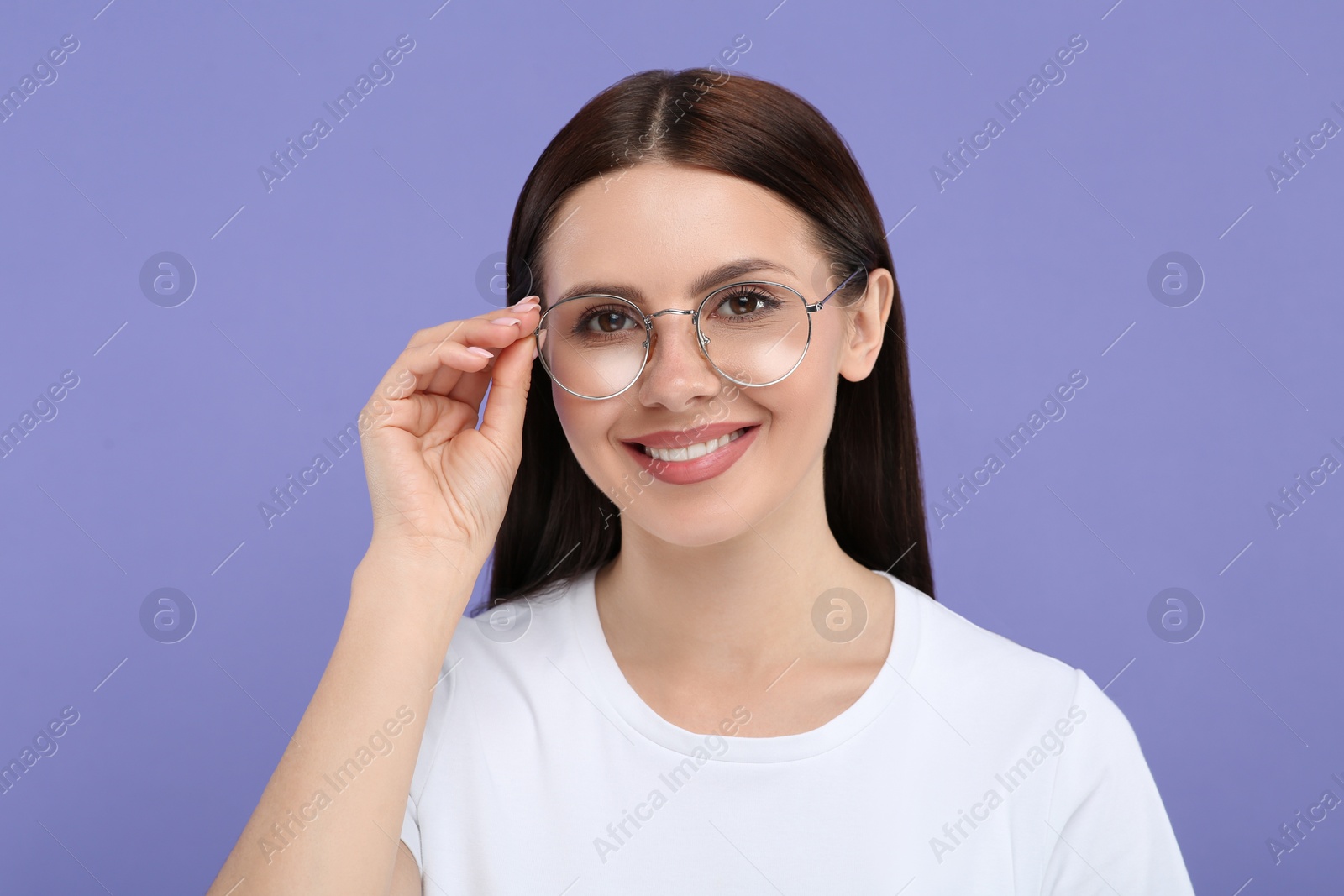 Photo of Portrait of smiling woman in stylish eyeglasses on violet background