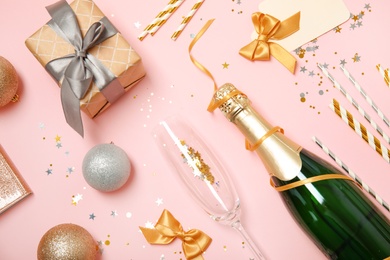 Photo of Creative flat lay composition with bottle of champagne and party accessories on color background