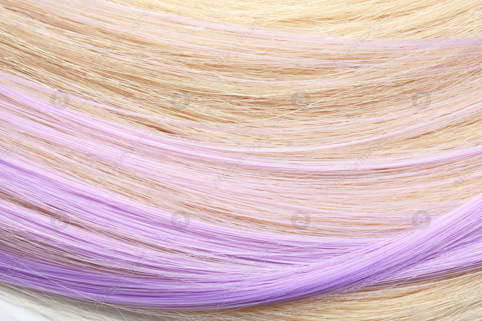 Photo of Strands of blond and violet hair as background, closeup