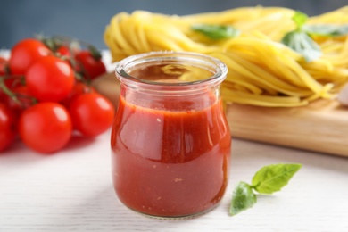 Photo of Jar of tasty tomato sauce served on table