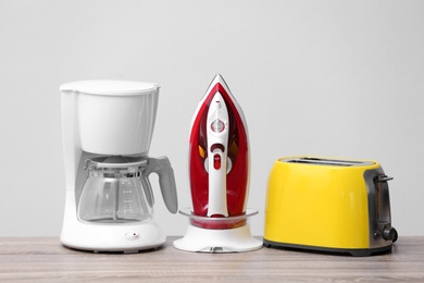 Photo of Household and kitchen appliances on table against light background. Interior element