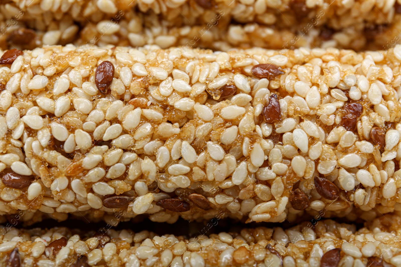 Photo of Tasty sesame seed bars as background, closeup