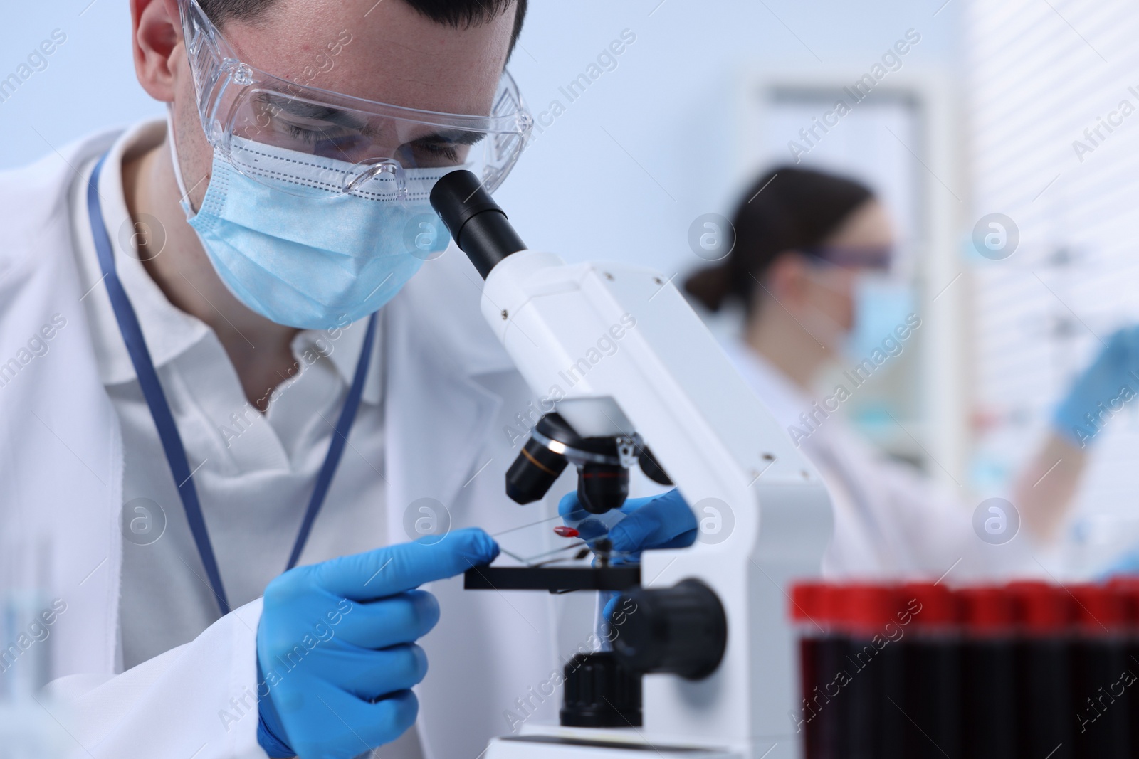 Photo of Scientist working with microscope in laboratory, closeup