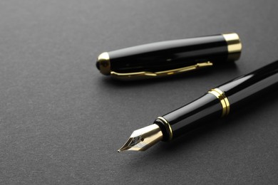 Photo of Stylish fountain pen with cap on black background, closeup. Space for text