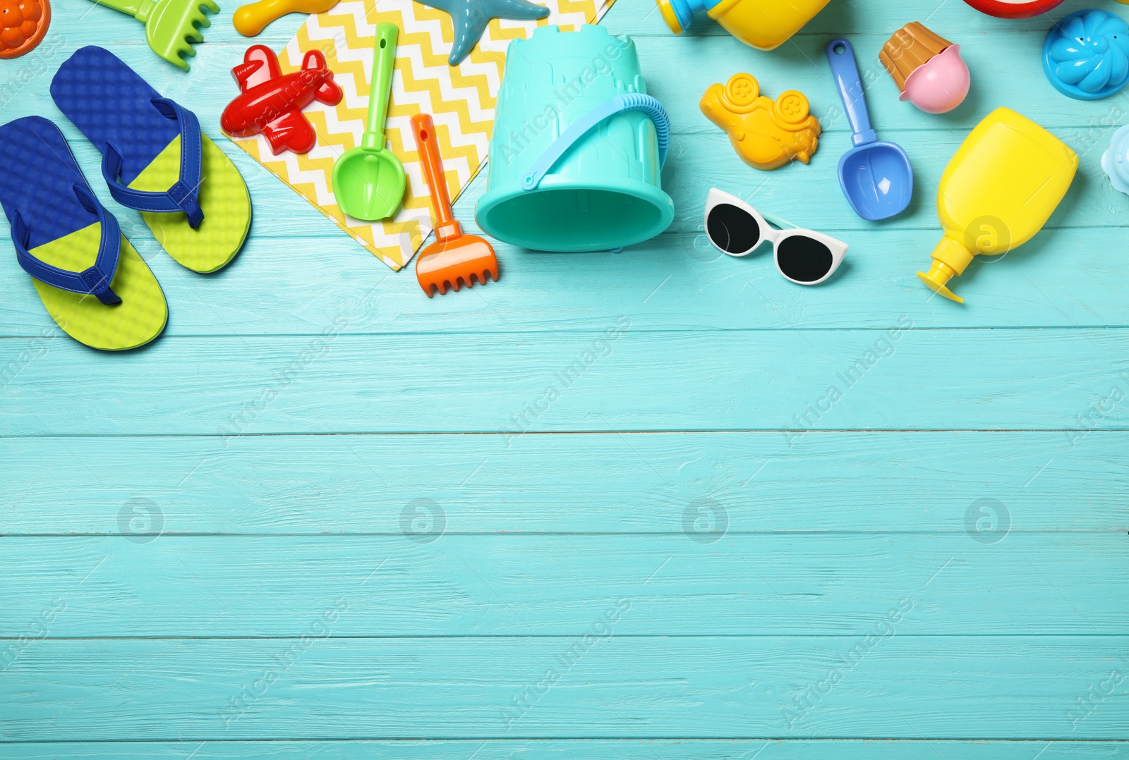 Photo of Flat lay composition with beach toys on color wooden background. Space for text