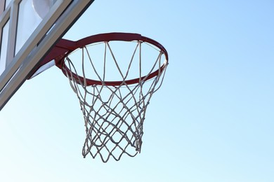 Basketball hoop with net outdoors on sunny day