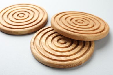 Photo of Stylish wooden cup coasters on light background