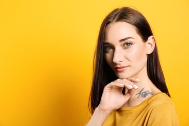 Photo of Portrait of pretty young woman with gorgeous chestnut hair on yellow background, space for text