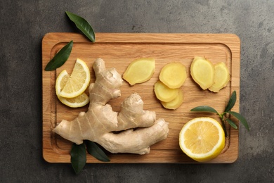 Photo of Fresh lemon and ginger on grey table, top view