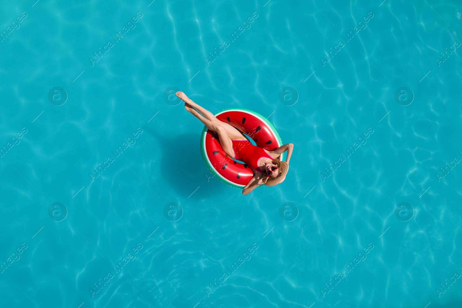 Image of Young happy woman with inflatable ring in swimming pool, top view. Summer vacation