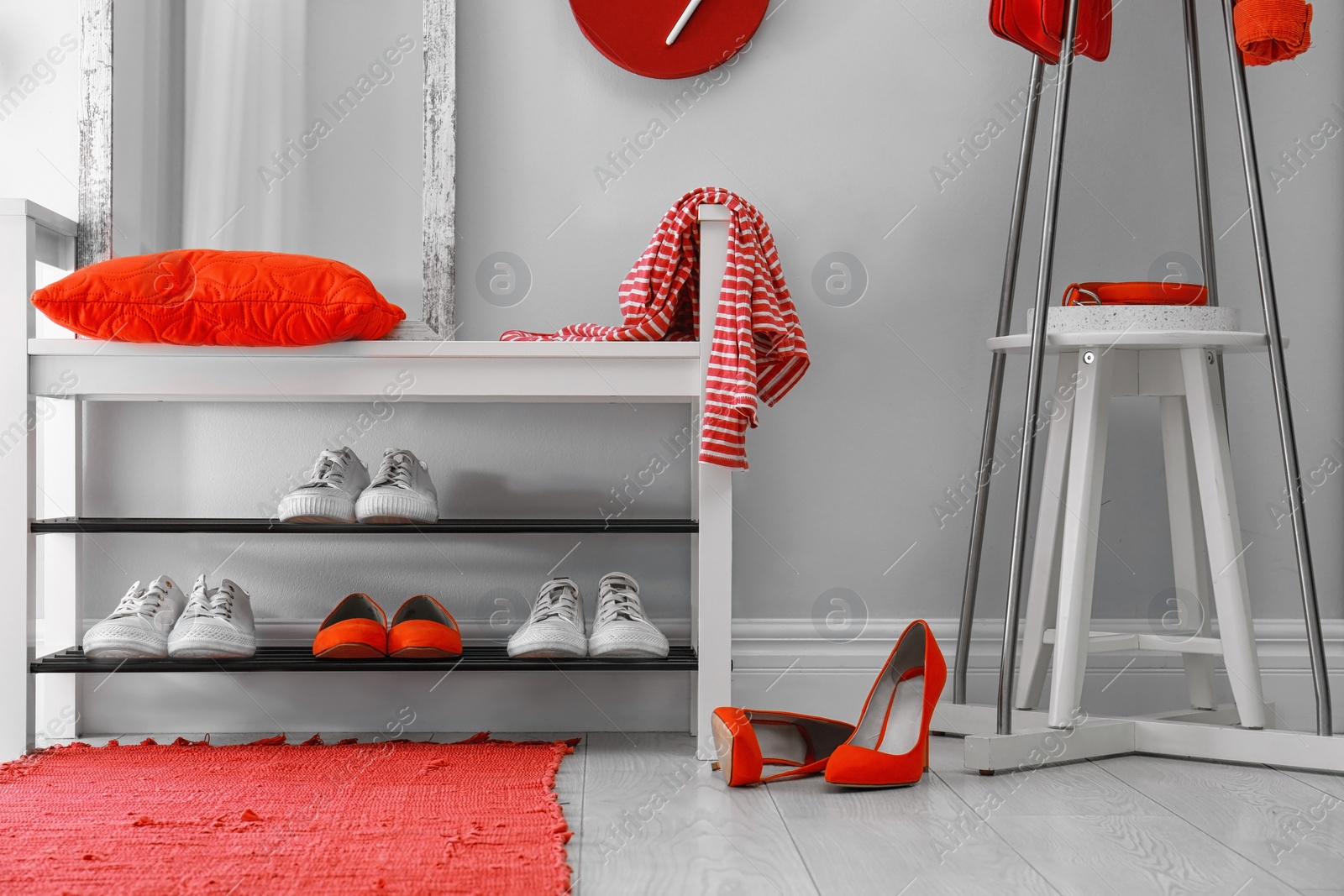 Stylish hallway interior with shoe rack and rug Photo of Stylish hallway interior with shoe rack and rug