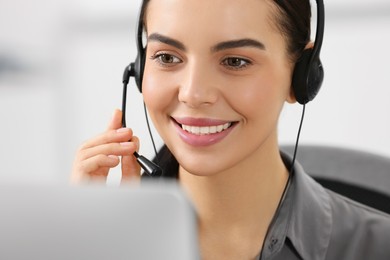 Hotline operator with headset working on computer in office