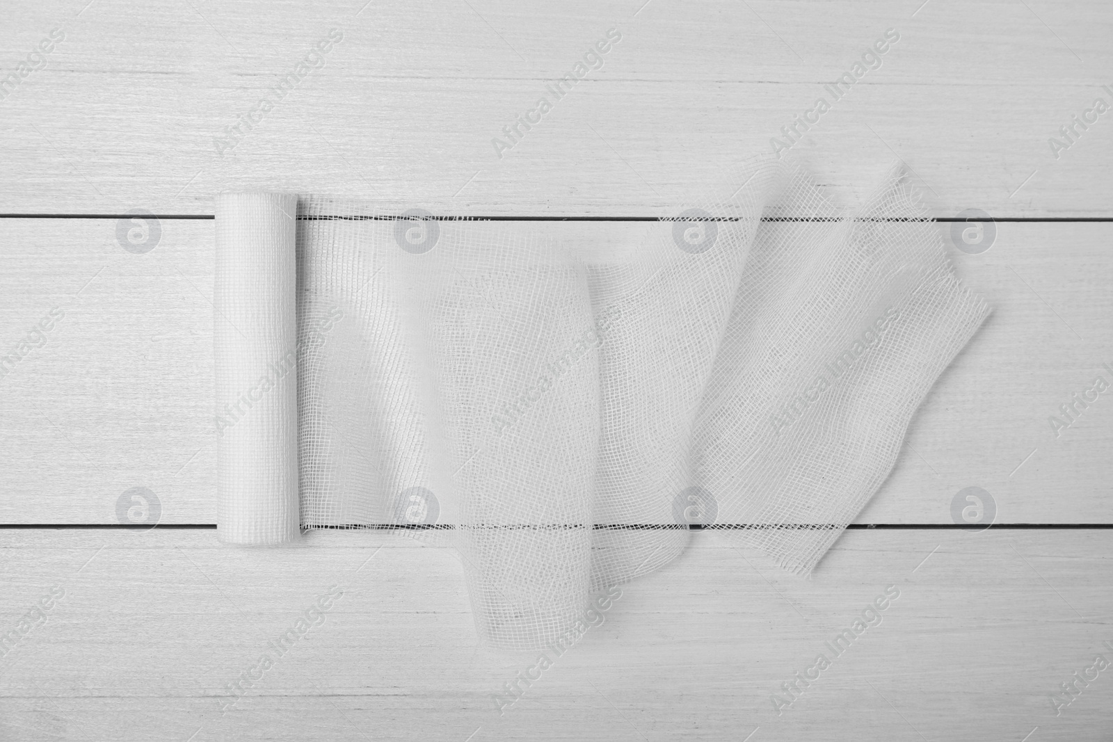 Photo of Medical bandage on white wooden table, top view