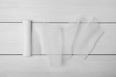 Photo of Medical bandage on white wooden table, top view