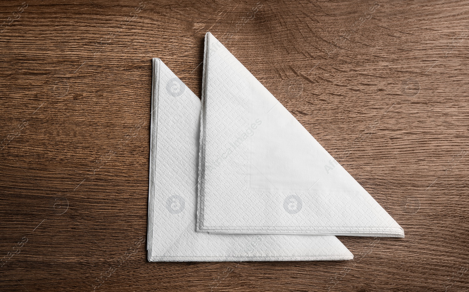 Photo of Folded white clean paper tissues on wooden table, flat lay