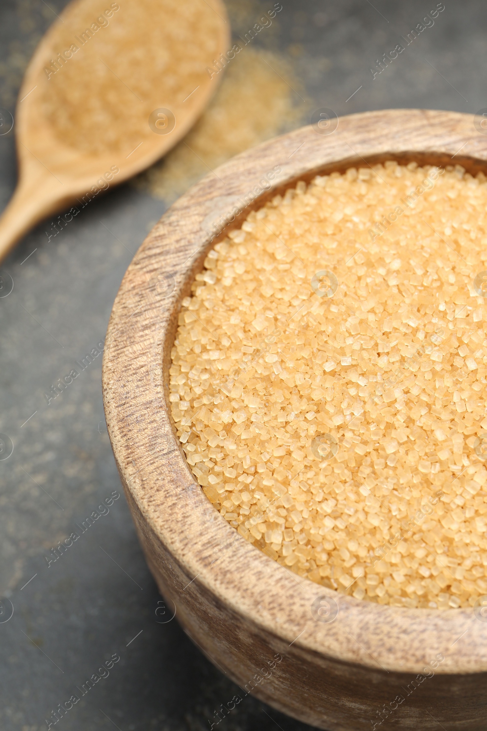 Photo of Brown sugar in bowl on grey table, closeup