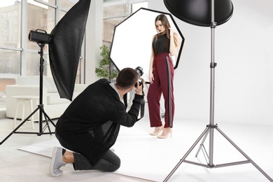 Beautiful young model posing for professional photographer in studio