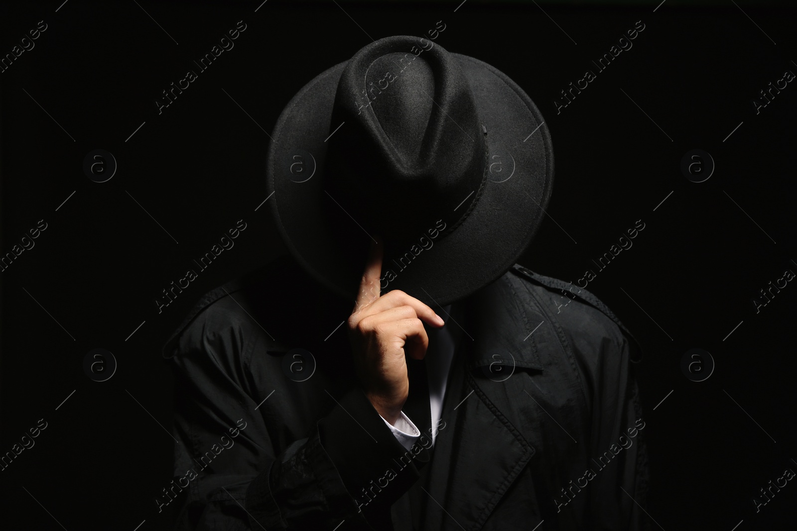 Photo of Old fashioned detective in hat on dark background