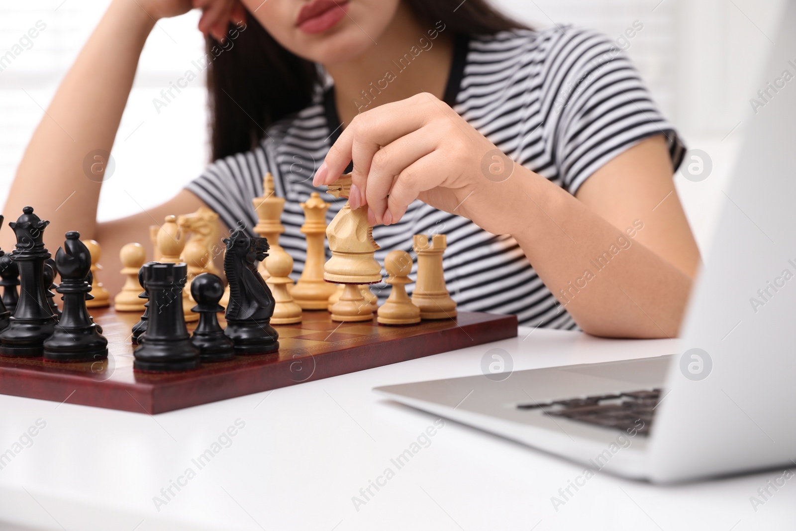Photo of Woman playing chess with partner through online video chat at home, closeup