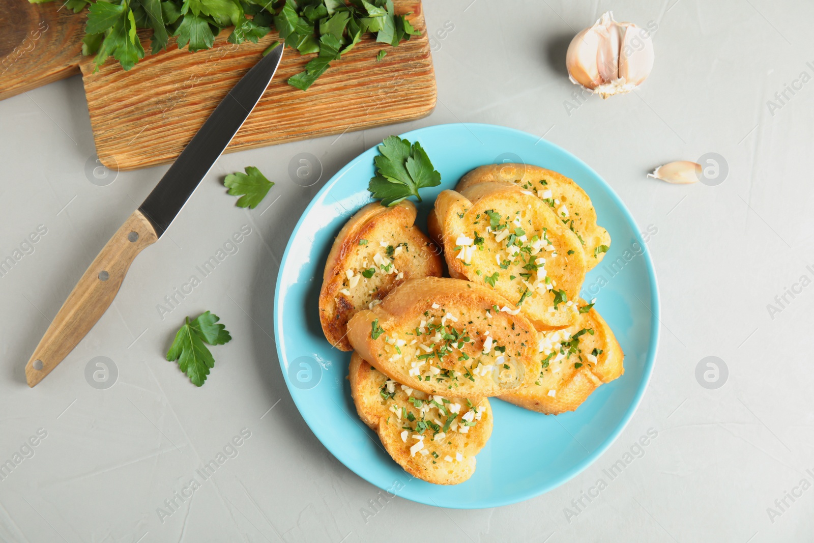 Photo of Flat lay composition with tasty homemade garlic bread on table