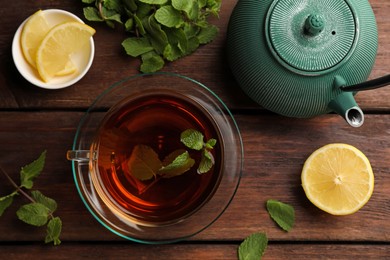 Photo of Aromatic herbal tea with mint and lemon on wooden table. Space for text
