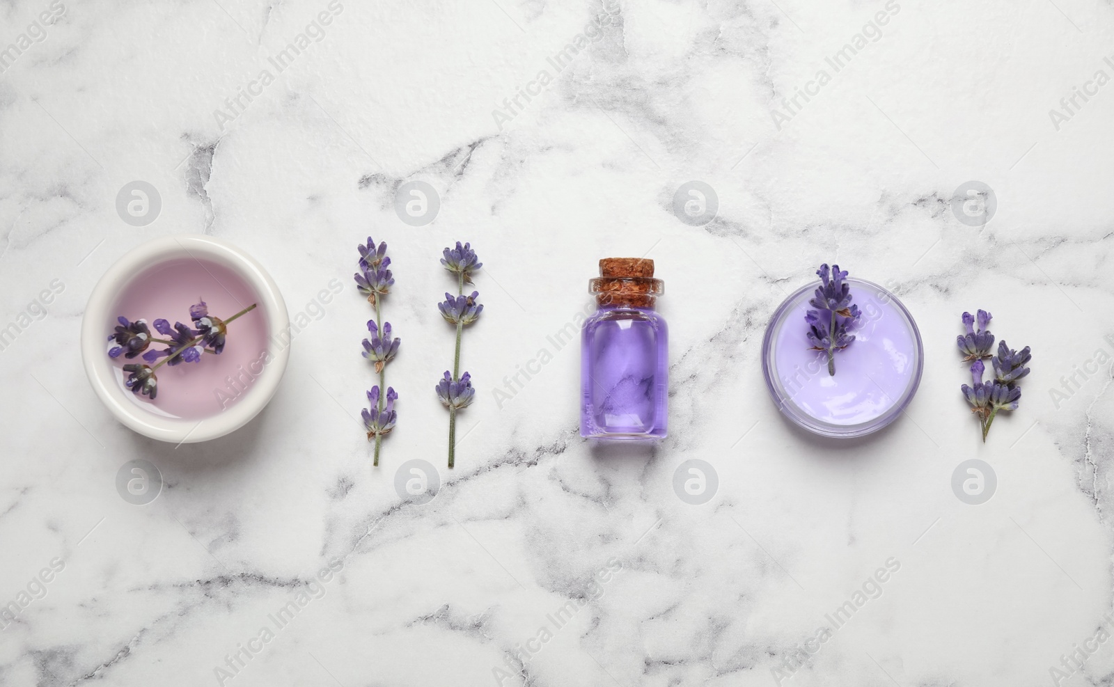 Photo of Cosmetic products and lavender flowers on white marble table, flat lay