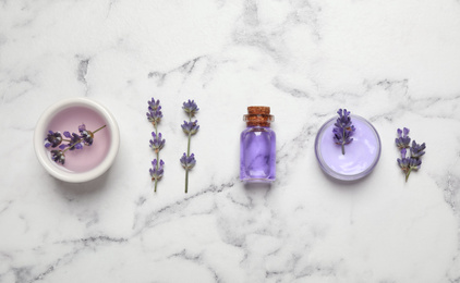 Photo of Cosmetic products and lavender flowers on white marble table, flat lay