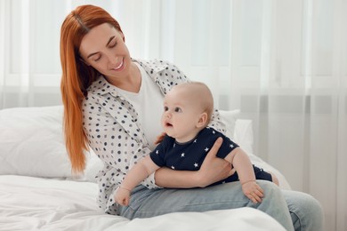 Photo of Mother playing with her cute baby in bedroom