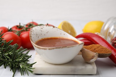 Photo of Fresh marinade and different ingredients on white table, closeup