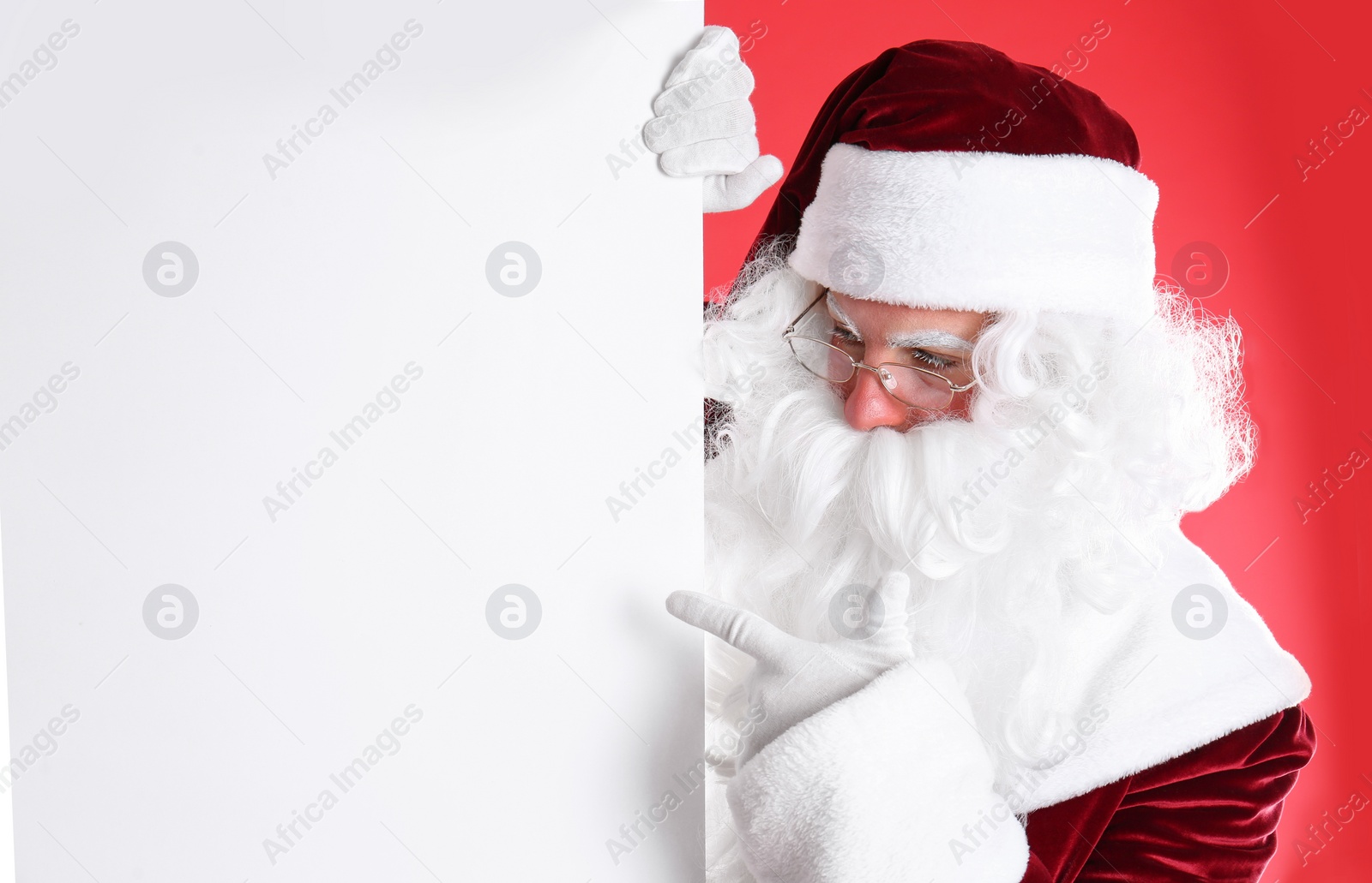 Photo of Santa Claus holding empty banner on red background