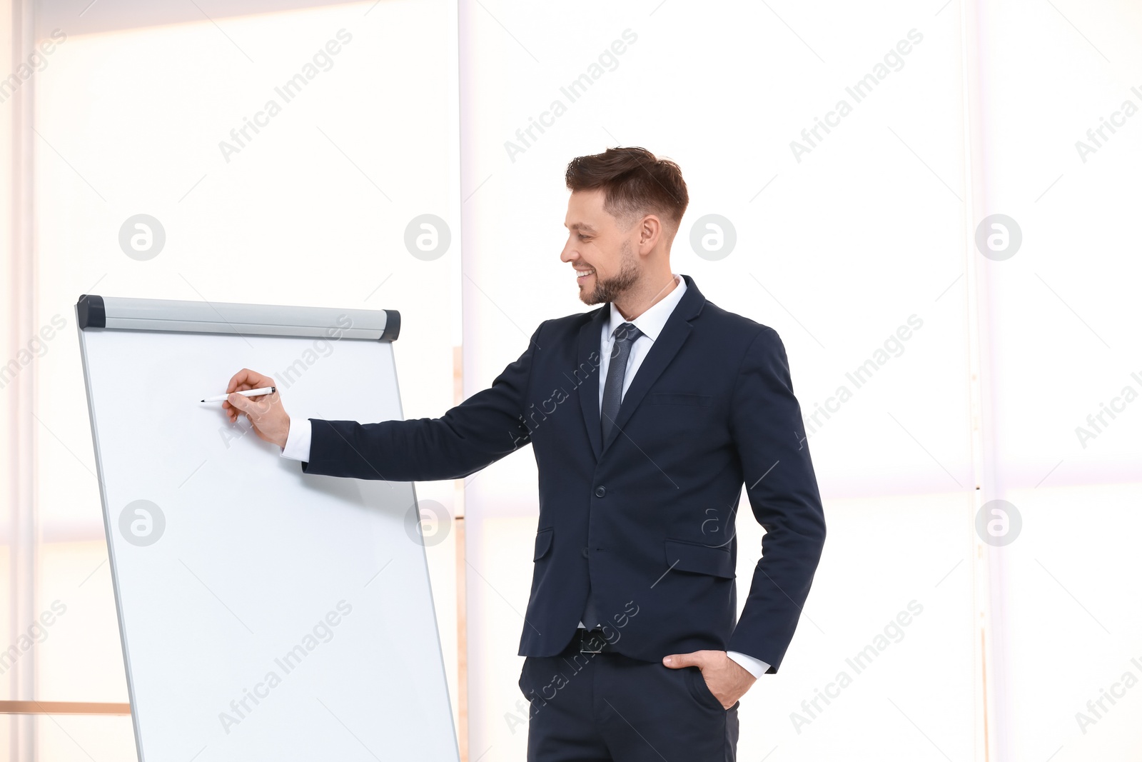 Photo of Young business trainer near flip chart, indoors